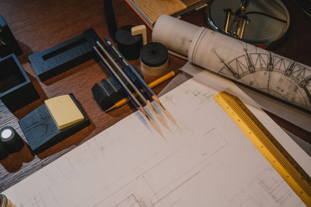 pexels-photo-9617366 Architect's desk with blueprints and drafting tools, perfect for design and planning themes.
